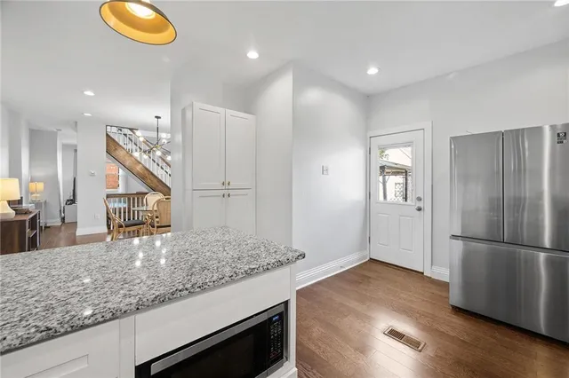a kitchen with stainless steel appliances granite countertop a refrigerator and a sink