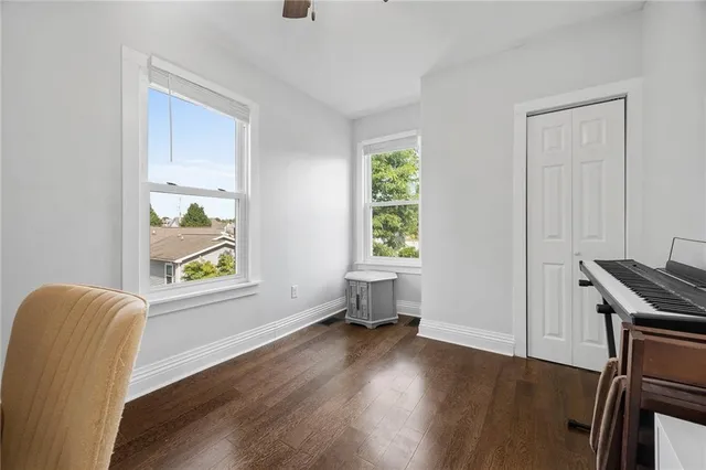 a view of an empty room with a window and wooden floor