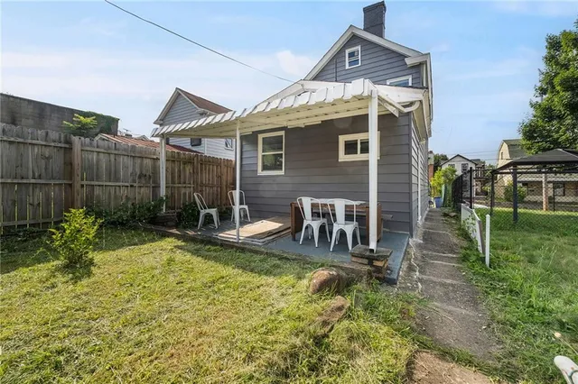 a view of a house with backyard and sitting area