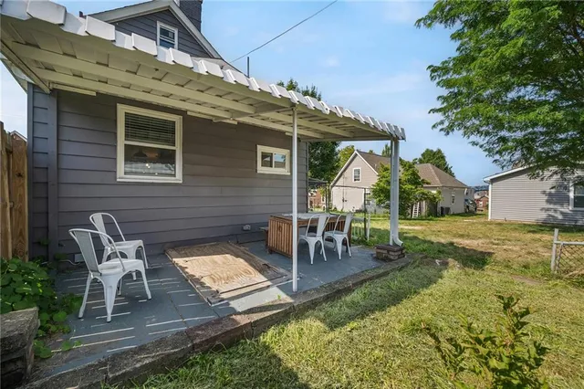 a view of a patio with table and chairs with wooden fence and plants