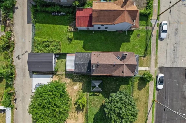 an aerial view of residential house with outdoor space and trees all around