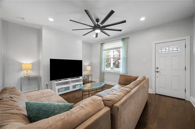 a living room with furniture and a flat screen tv with wooden floor
