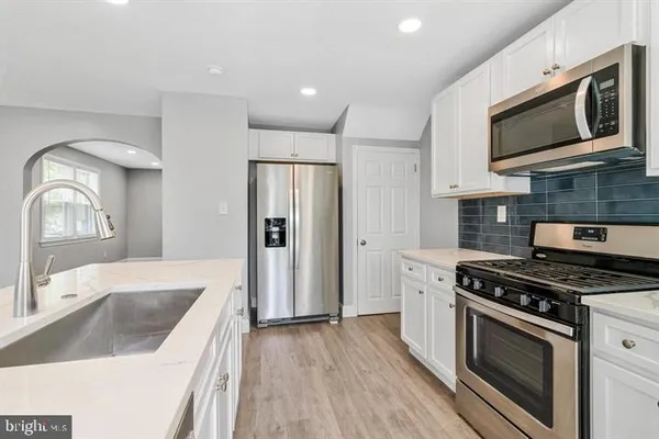 a kitchen with stainless steel appliances granite countertop a stove a sink and a microwave