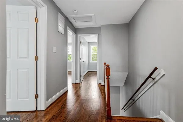 a view of a hallway with wooden floor and stairs