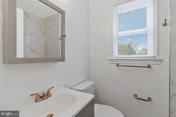 a bathroom with a sink a toilet and mirror