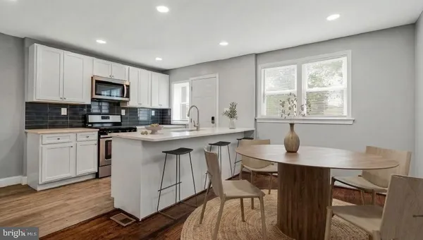 a kitchen with stainless steel appliances granite countertop a sink a stove a microwave a refrigerator and cabinets