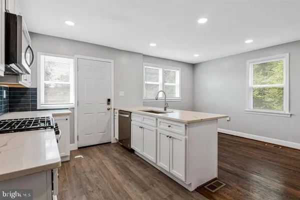 a kitchen with sink cabinets and wooden floor