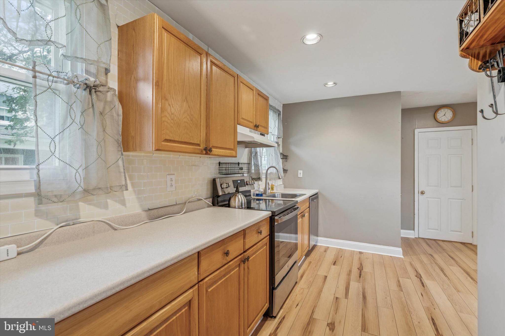 633 East Manoa Road Havertown, PA 19083 - Photo 16 of 25 a kitchen with a sink a stove cabinets and wooden floor