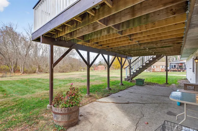 a view of a roof deck with table and chairs a barbeque with wooden floor
