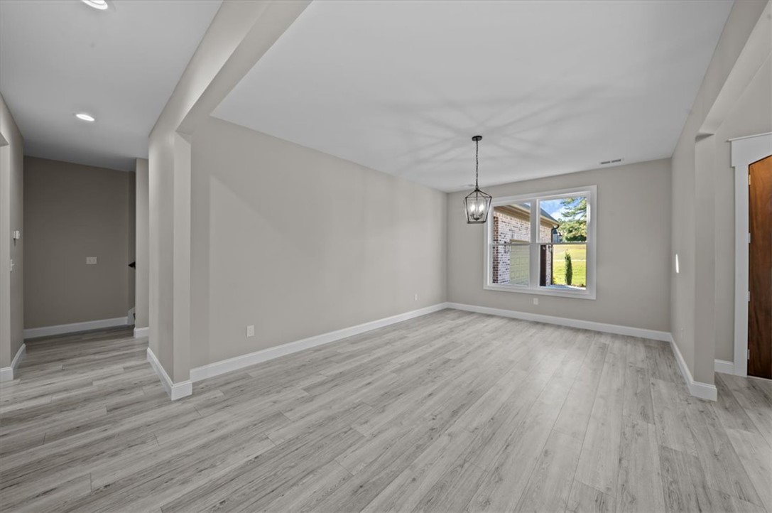 105 Bree Drive Anderson, SC 29621 - Photo 23 of 48 A spacious, naturally illuminated room featuring durable plank flooring and a modern ceiling fixture.