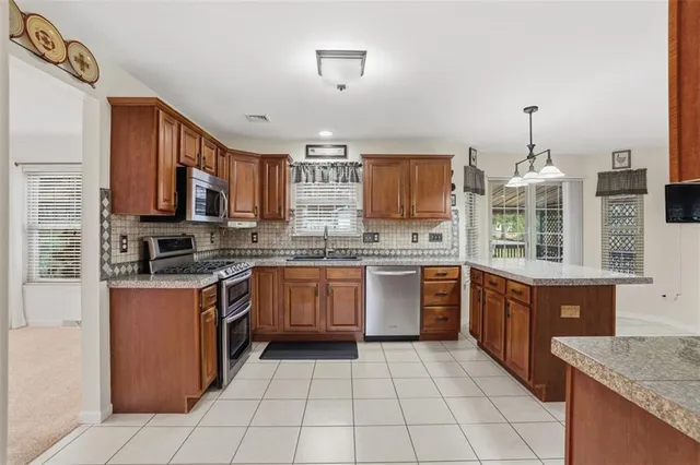 a kitchen with stainless steel appliances granite countertop a stove sink and cabinets