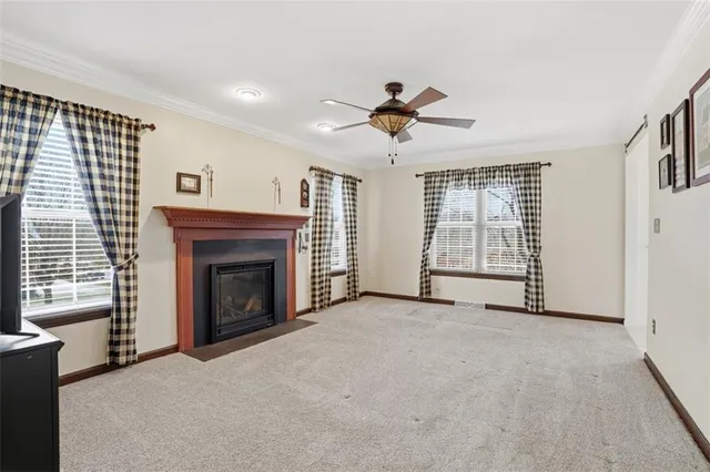 a view of an empty room with a fireplace and a window
