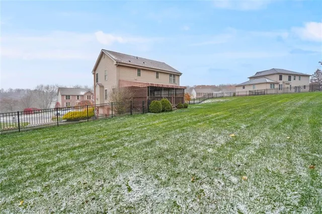 a view of a house with a big yard and large trees