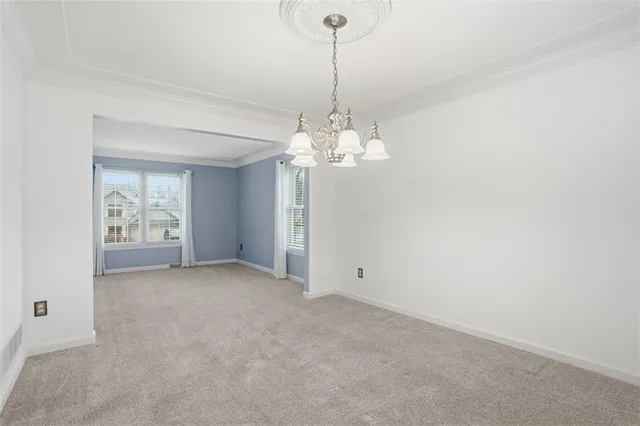 a view of a chandelier in big room and a bathroom