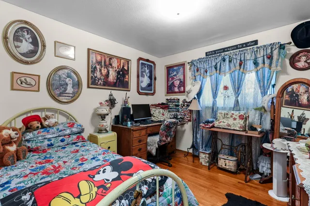 a bedroom with a bed a clock and a desk