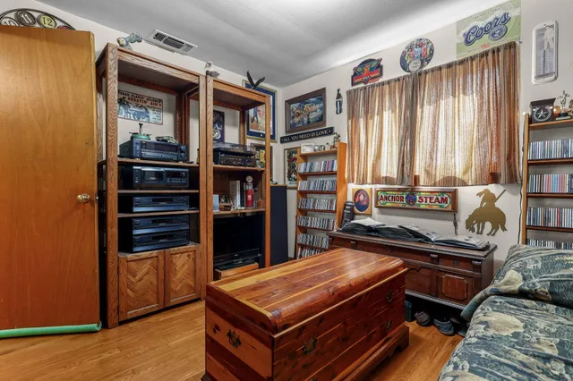 a living room with furniture a bookshelf and a window