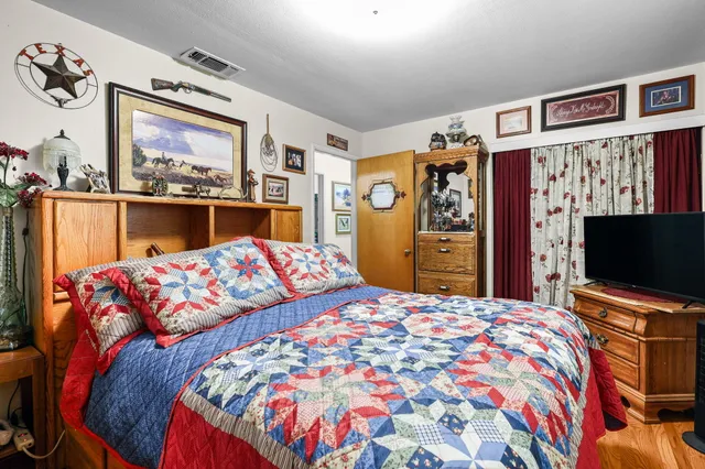 a bedroom with a bed window and flat screen tv