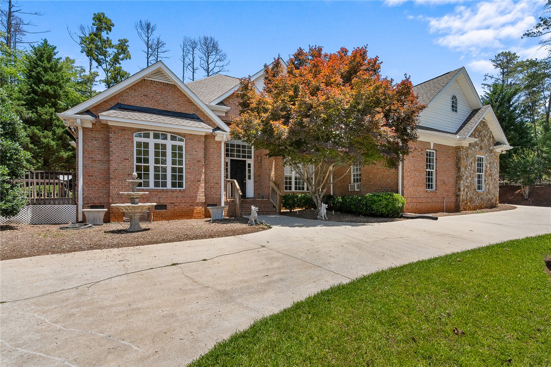 135 Sunset Bay Boulevard Seneca, SC 29672 - Photo 4 of 50 Brick and stone exterior with a decorative fountain and mature landscaping create a welcoming entry.