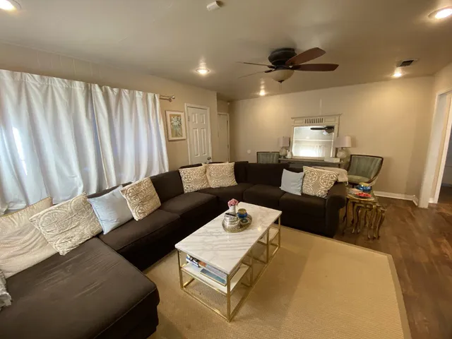 a living room with furniture and a wooden floor