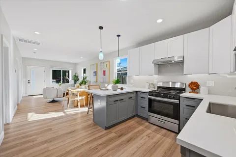 a kitchen with a table chairs and a wooden floor