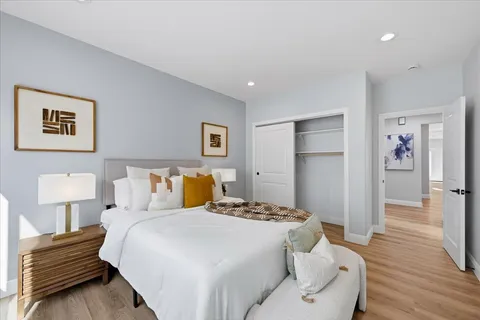a bedroom with a bed and wooden floor
