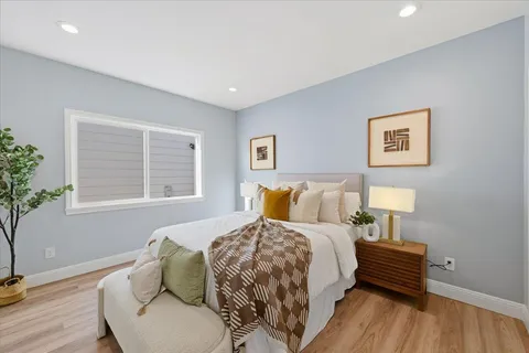 a bedroom with a bed and a painting on the wall