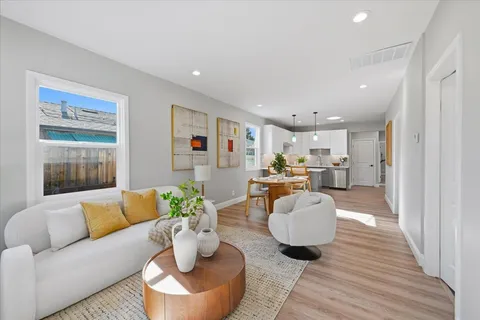 a living room with furniture and a wooden floor