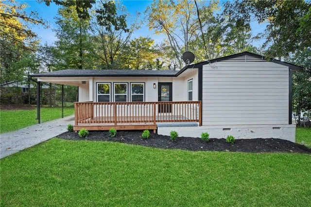 a view of a house with a yard and deck