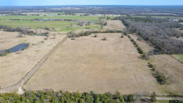 a view of a big yard with trees in the background