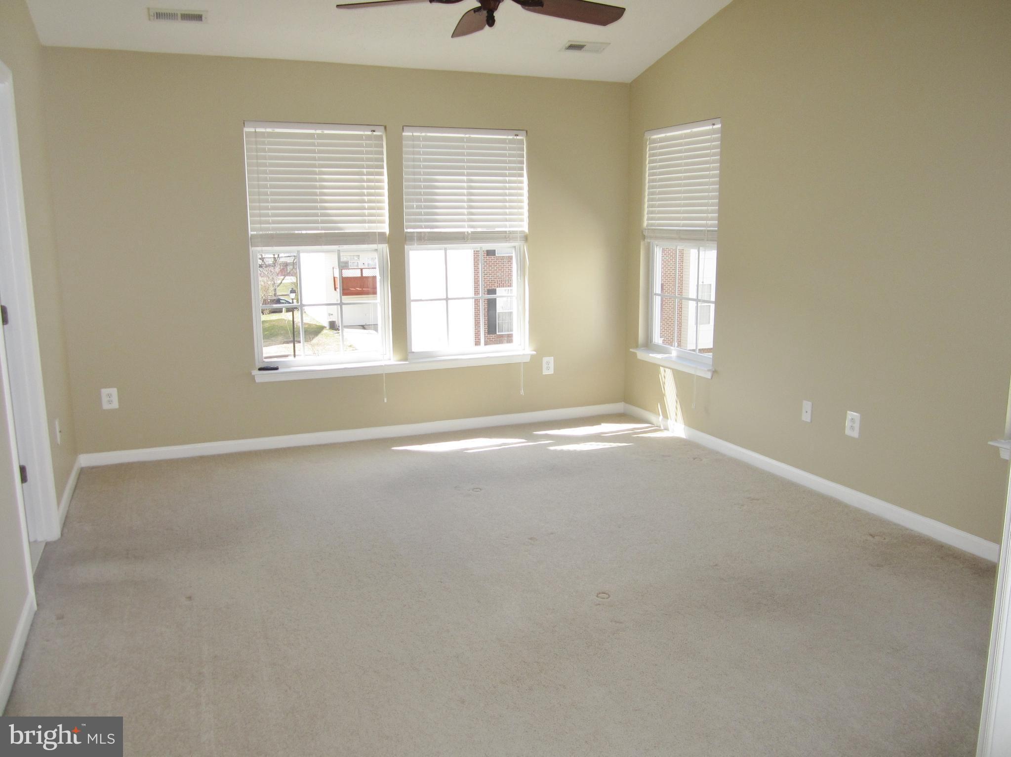 829 Lowe Road Baltimore, MD 21220 - Photo 11 of 28 an empty room with a windows and chandelier fan