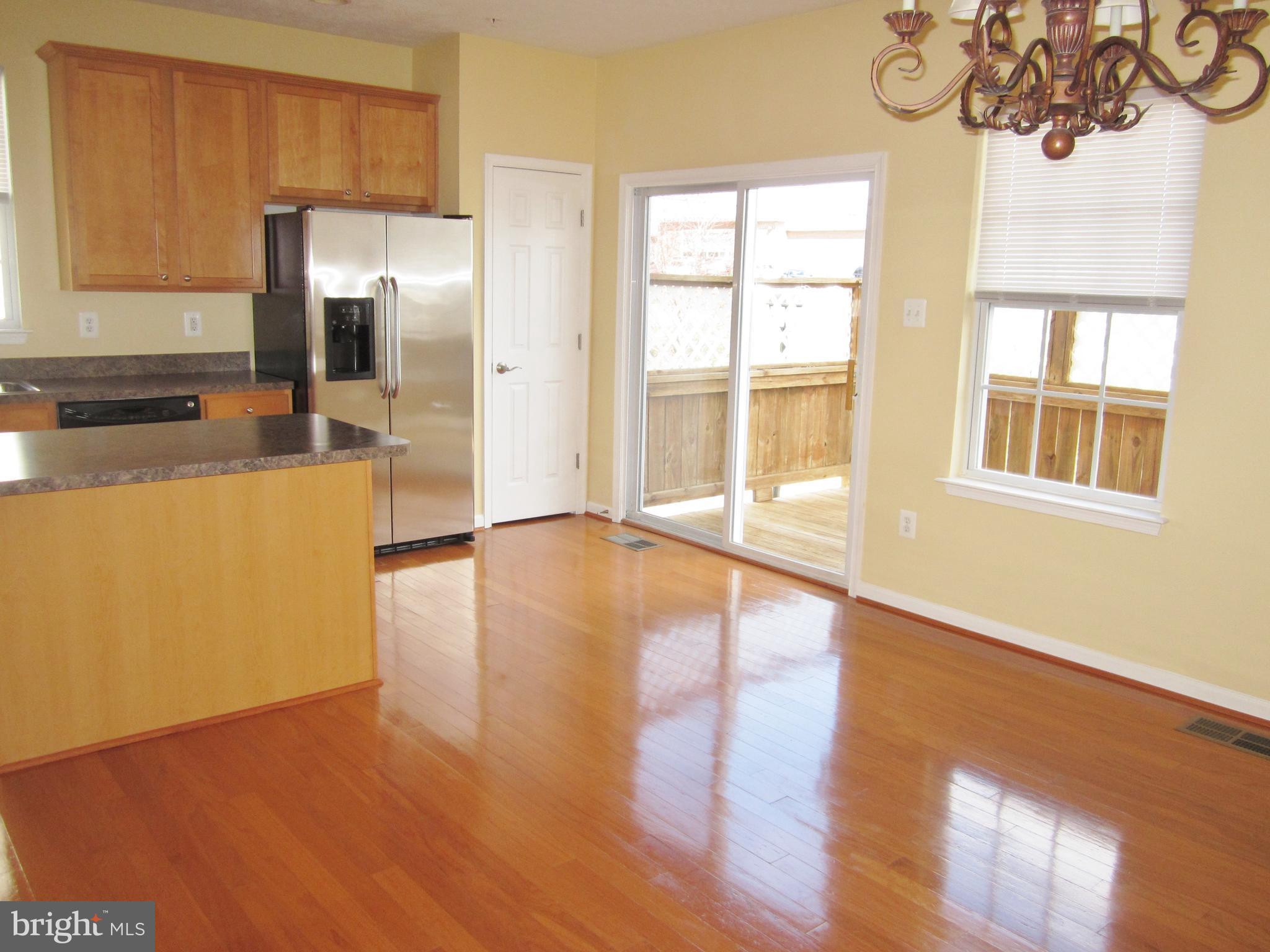 829 Lowe Road Baltimore, MD 21220 - Photo 9 of 28 a view of a kitchen with wooden floor and a refrigerator