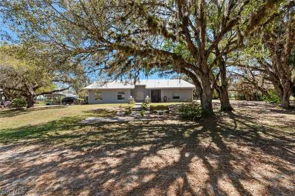 a front view of a house with a yard and trees