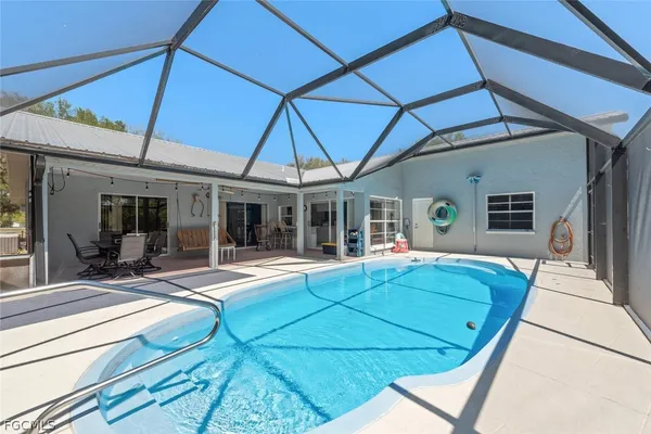 a view of house with swimming pool and furniture