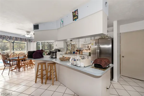 a kitchen with kitchen island a counter top space a sink appliances and cabinets