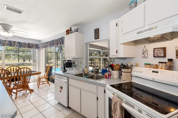 a kitchen filled with a white stove top oven and cabinets