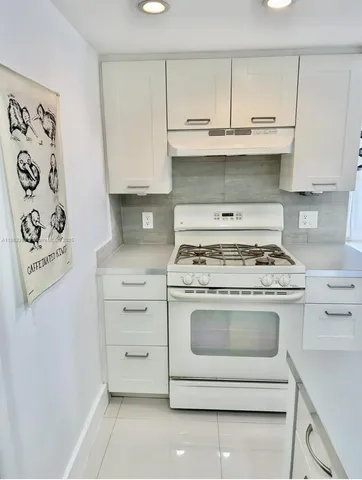a stove top oven sitting inside of a kitchen