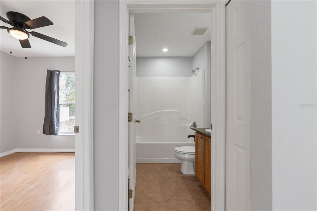 17168 Southwest 39th Circle Ocala, FL 34473 - Photo 19 of 36 a bathroom with a granite countertop toilet and a shower