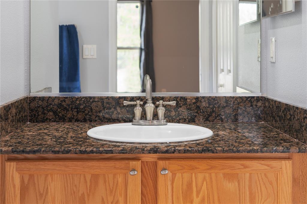 17168 Southwest 39th Circle Ocala, FL 34473 - Photo 25 of 36 a bathroom with a granite countertop sink and a mirror