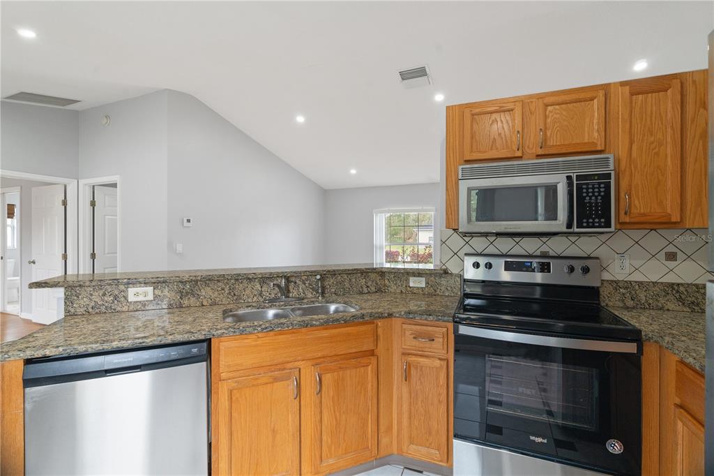 17168 Southwest 39th Circle Ocala, FL 34473 - Photo 10 of 36 a kitchen with stainless steel appliances granite countertop a stove microwave and oven
