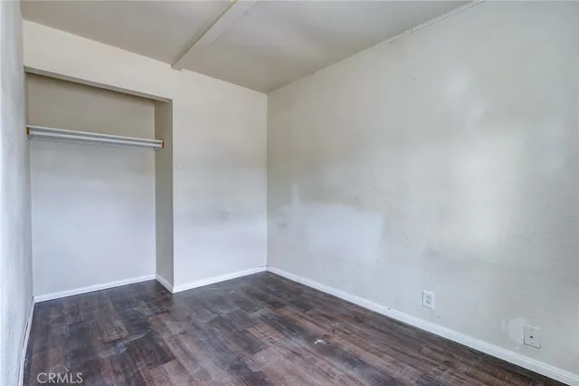 an empty room with wooden floor and sliding door