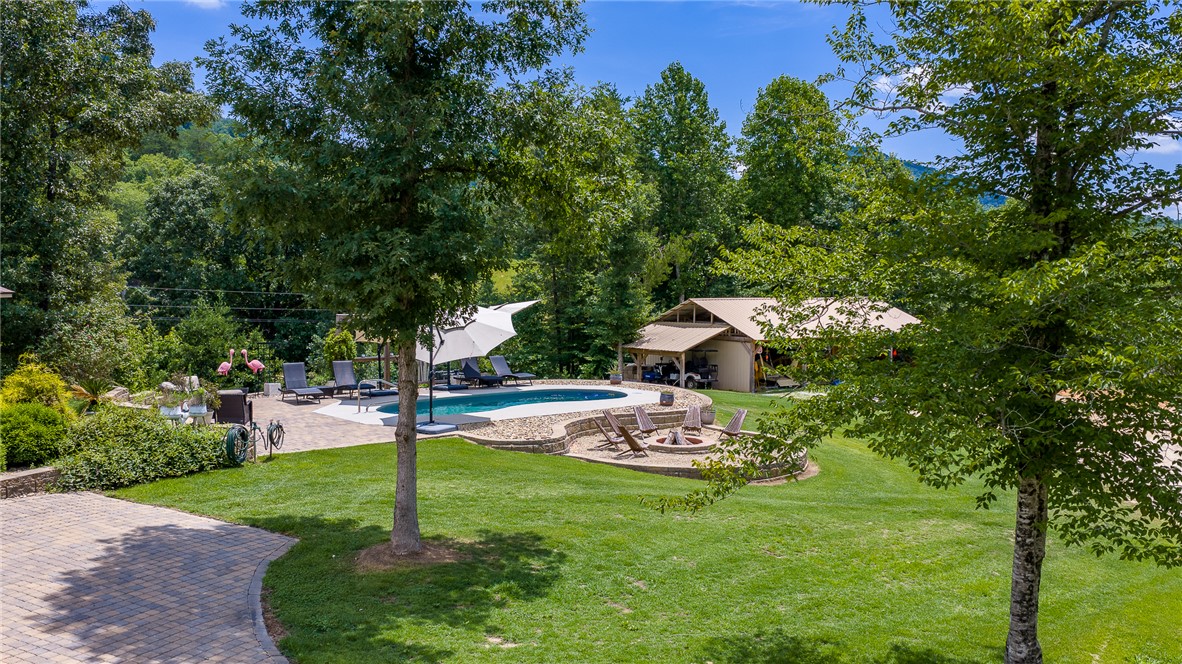 183 Little Eastatoee Road Sunset, SC 29685 - Photo 48 of 50 An inviting outdoor oasis features a refreshing pool, paved patio, and a fire pit, all set within a lush, private yard.