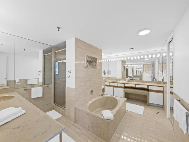 a large bathroom with a tub a sink shower and mirror