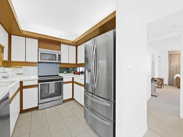 a kitchen with stainless steel appliances granite countertop a refrigerator and a stove top oven
