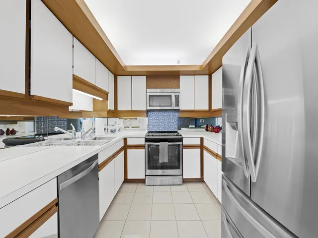 a kitchen with stainless steel appliances granite countertop a stove a sink and a refrigerator