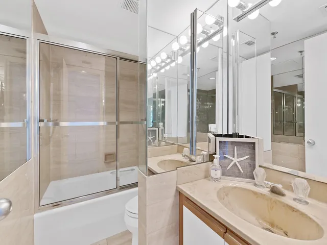 a bathroom with a granite countertop sink mirror and shower