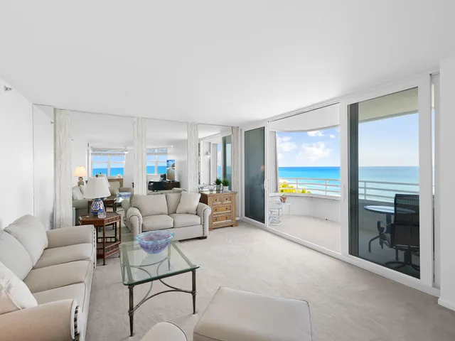 a living room with furniture and floor to ceiling window