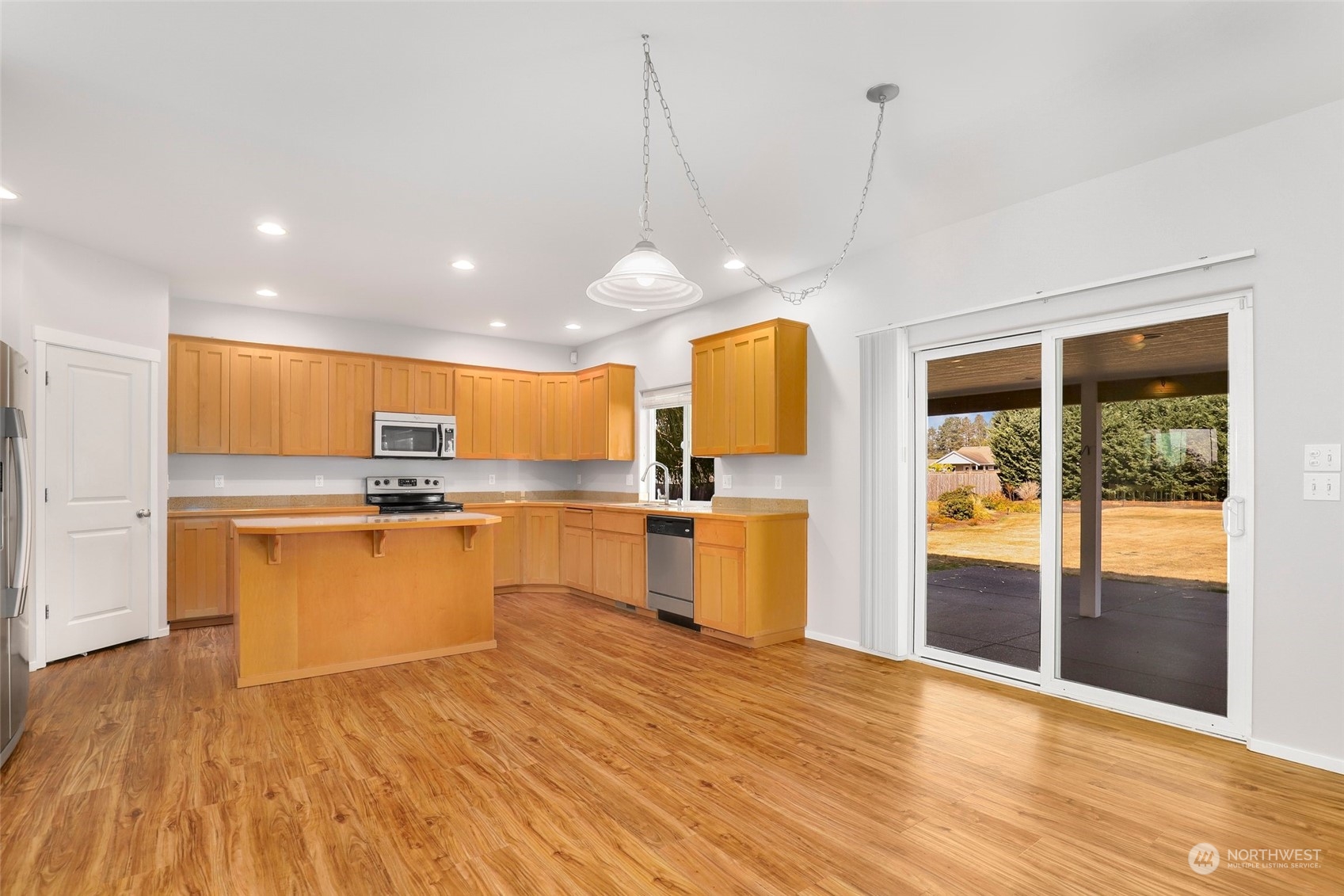 4633 181st Lane Southwest Rochester, WA 98579 - Photo 11 of 40 a open kitchen with stainless steel appliances granite countertop a refrigerator a sink dishwasher a oven and a dining table with wooden floor