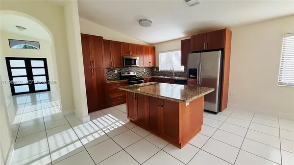 a kitchen with stainless steel appliances granite countertop a stove a refrigerator and a sink