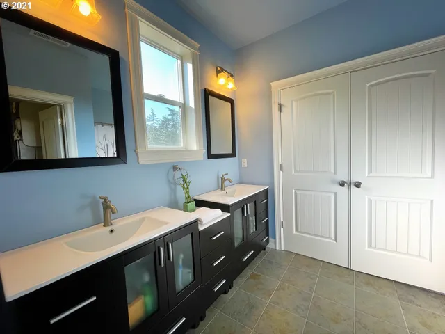 a bathroom with a double vanity sink a mirror and a bathtub