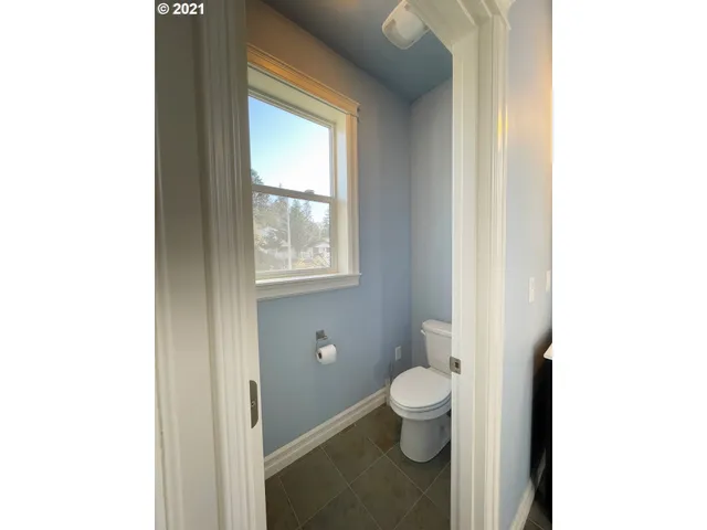 a bathroom with a toilet and a window